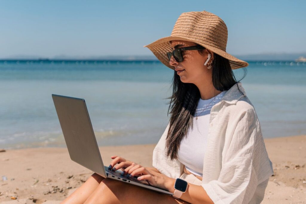 woman on beach with laptop